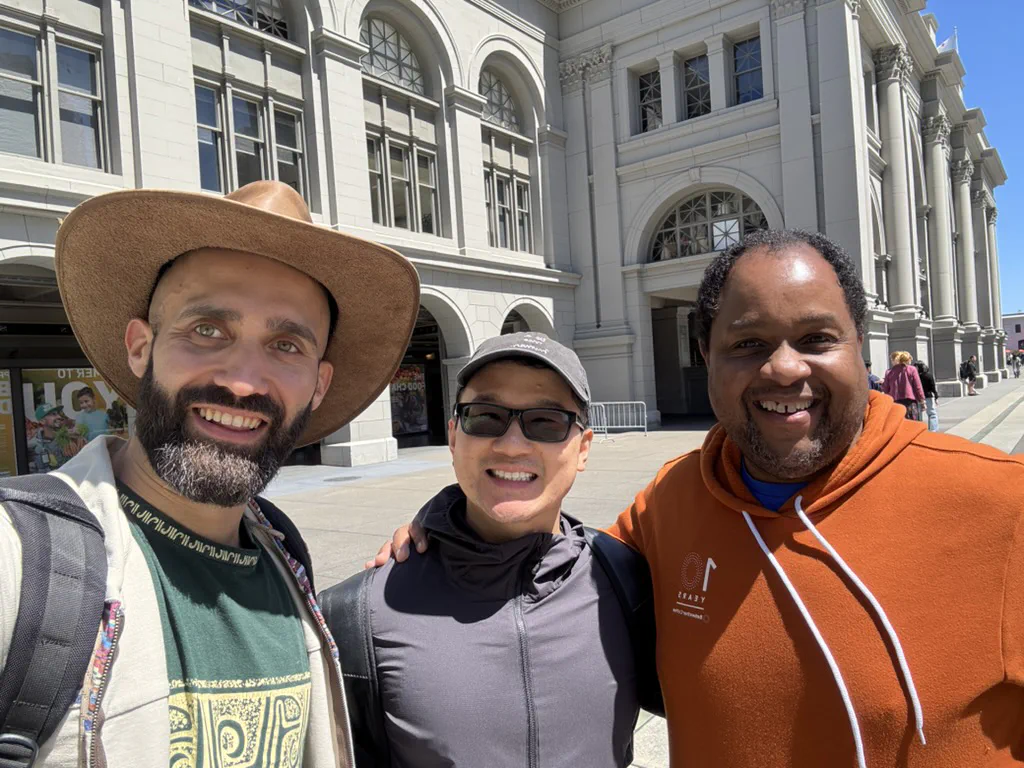 Three members of the Nexrizen team standing together outdoors, laughing.