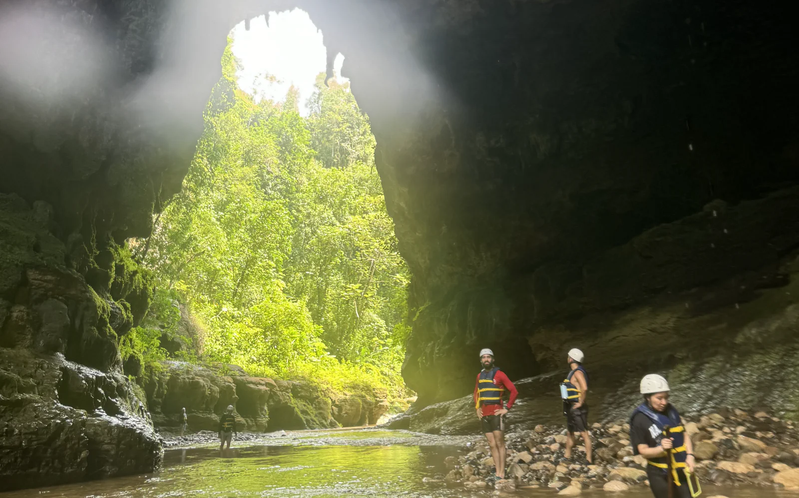 The Nexrizen team standing in a river at the mouth of a cave.